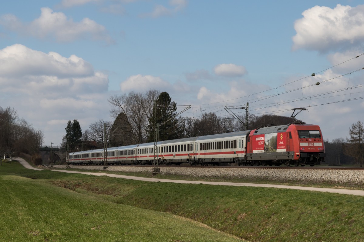 101 017-2 mit  Graub�nden -Werbung schiebend an einem IC am 3. April 2015 bei �bersee am Chiemsee.